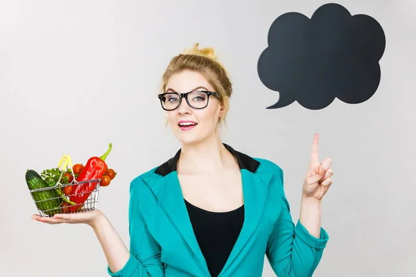 Woman holds shopping cart with vegetables, copy space — Stock Photo, Image