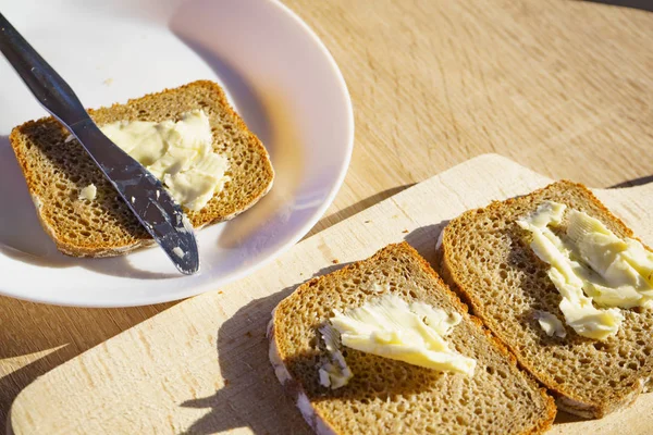 Pequeno-almoço. Fatias de pão de centeio com manteiga — Fotografia de Stock