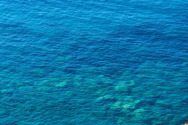 Чистая морская вода и камень в качестве фона — стоковое фото