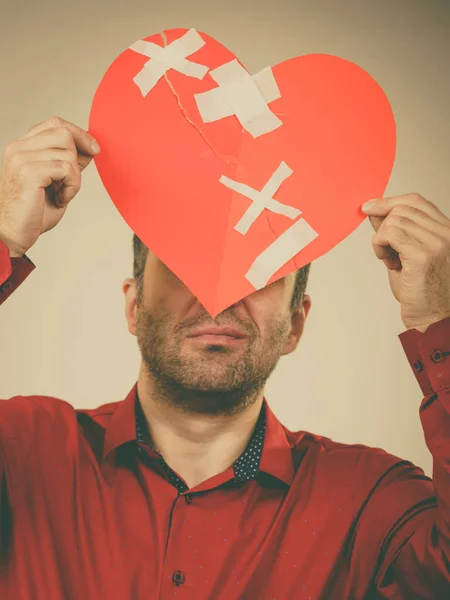 Vuxen man håller brustet hjärta — Stockfoto