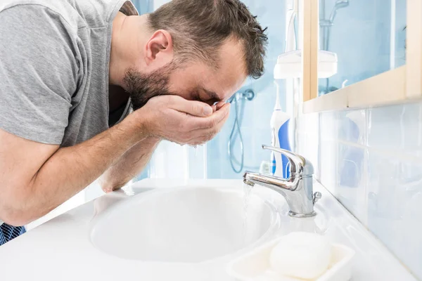 バスルームで顔を洗ってる男 — ストック写真