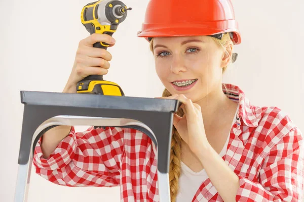 Woman wearing helmet using drill — Stock Photo, Image