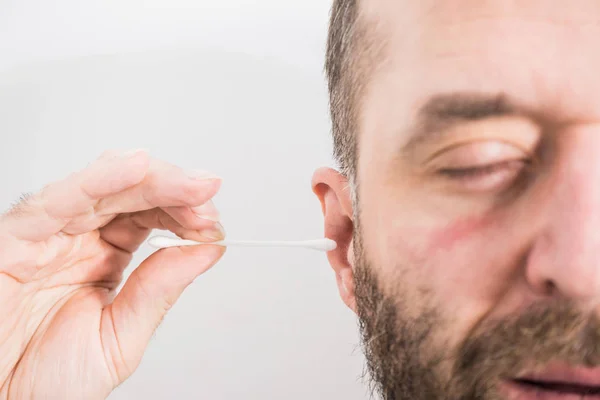 Homem removendo cera da orelha usando Q-tip — Fotografia de Stock