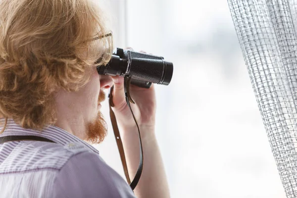 Muž s dalekohledem špehuje sousedy — Stock fotografie