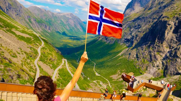 Trollstigen bakış açısıüzerinde Norveç bayrağı ile Turist — Stok fotoğraf