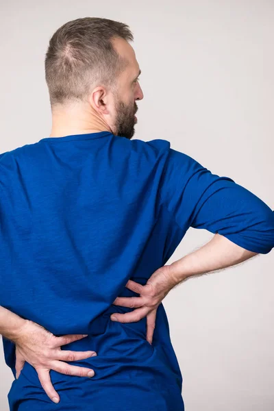 Hombre con dolor en los lomos de la espalda — Foto de Stock