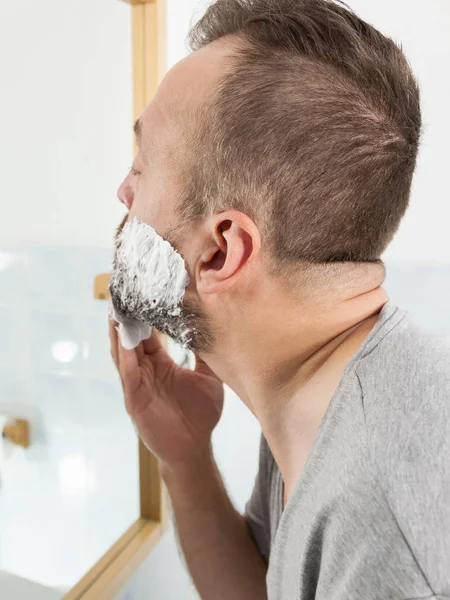 Homem aplicando creme de barbear na barba — Fotografia de Stock