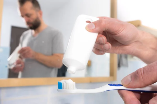 歯ブラシに歯磨き粉を置く人 — ストック写真