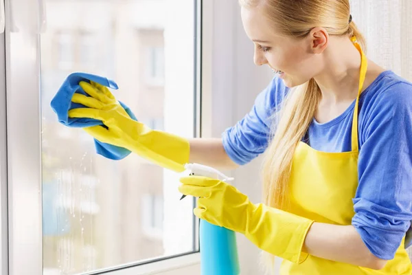 Женщина моет окно дома — стоковое фото