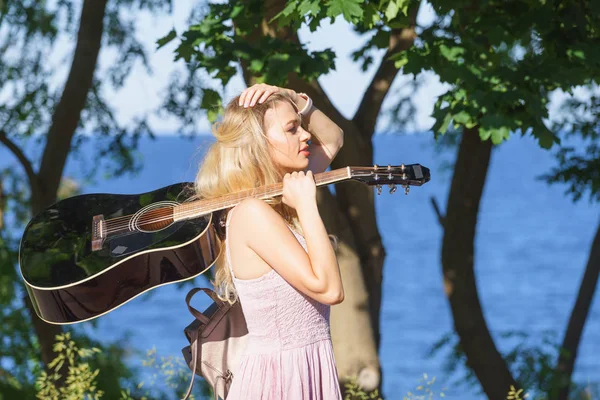 Žena hraje na akustickou kytaru v parku — Stock fotografie