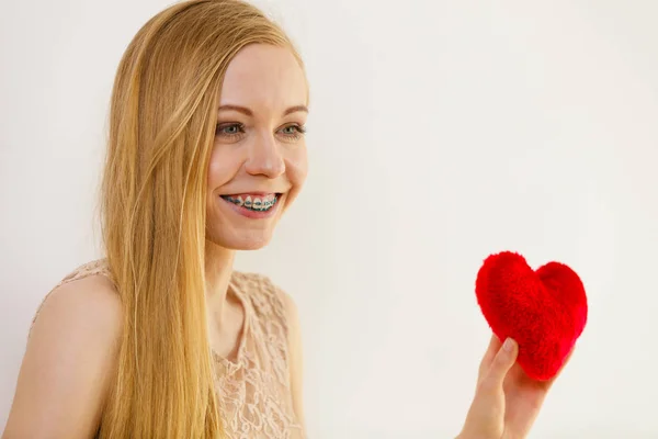 Gelukkige jonge vrouw die rood hart vasthoudt — Stockfoto