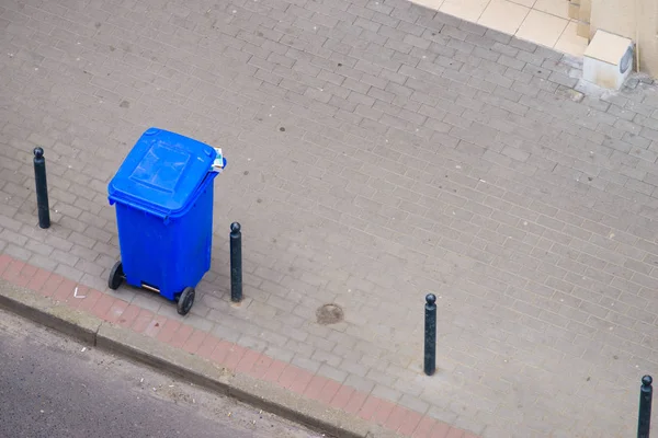 蓝色的垃圾桶在街头的人行道上 — 图库照片