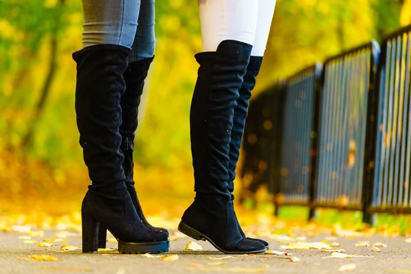 Twee vrouwen dragen zwarte knie hoge laarzen — Stockfoto