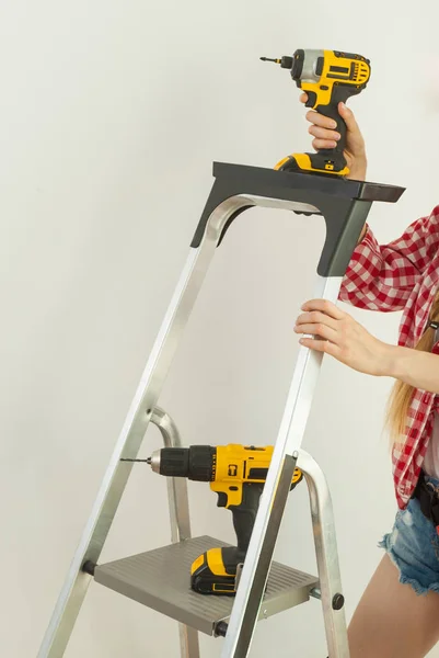 Женщина с ремонтными инструментами и лестницей — стоковое фото