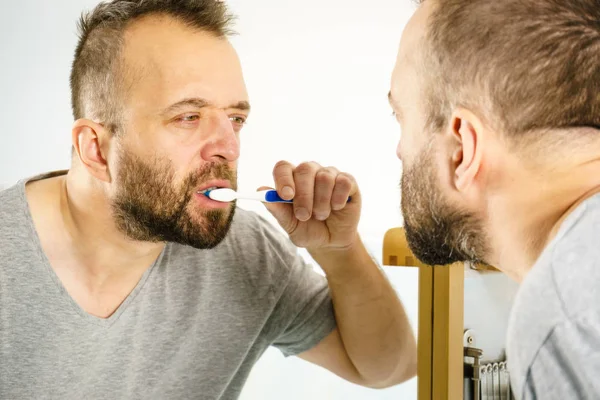 Мужчина чистит зубы в ванной — стоковое фото