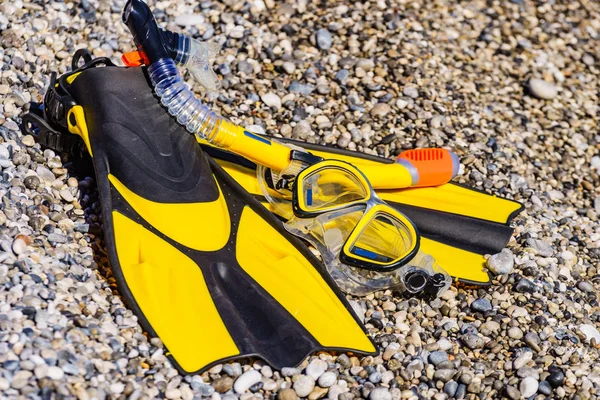 Aletas y tubo de snorkel en la orilla del mar — Foto de Stock