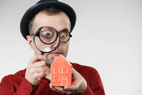 Man magnifying red house — Stock Photo, Image