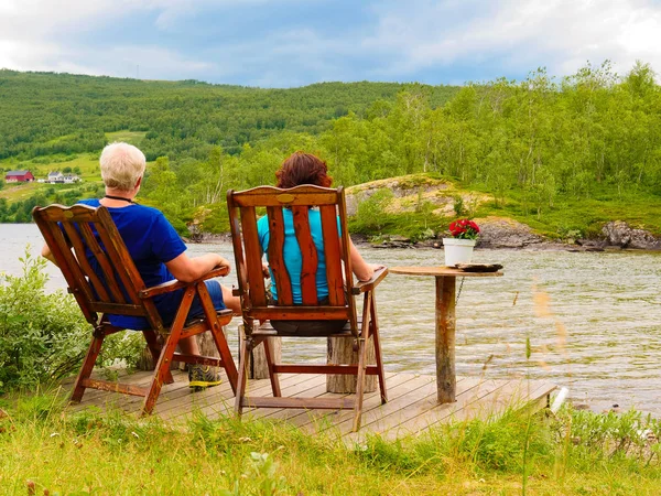 Couple relaxing on norwegian fjord shore Stock Picture