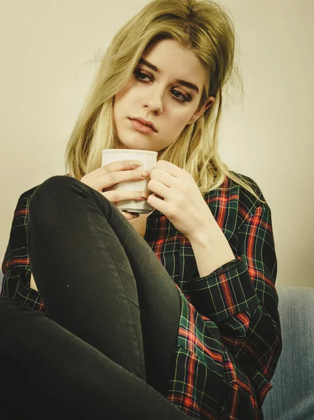 Triste mulher solitária sentada no sofá com caneca — Fotografia de Stock