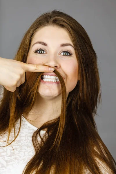 Mulher se divertindo com seu cabelo fazendo bigode — Fotografia de Stock