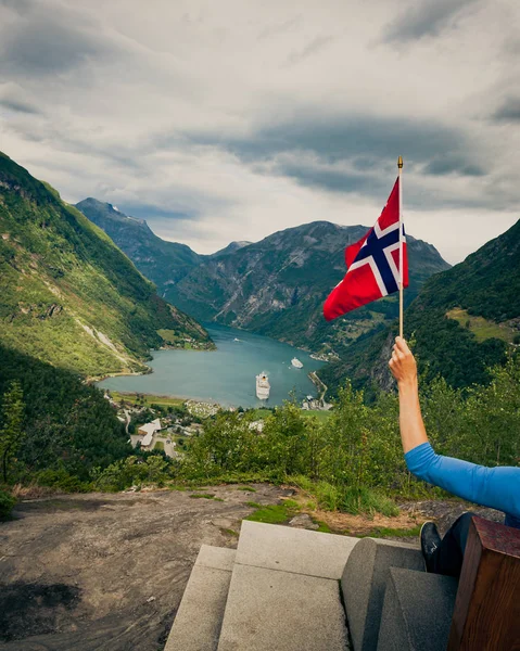 Турист над Гейрангер-фьордом держит флаг Норвегии — стоковое фото