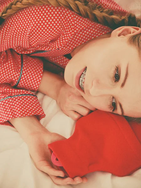 Kvinna som sover med varma röda varmvattenflaska — Stockfoto