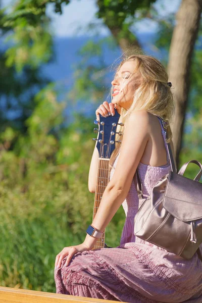 Vrouw speelt akoestische gitaar in het park — Stockfoto