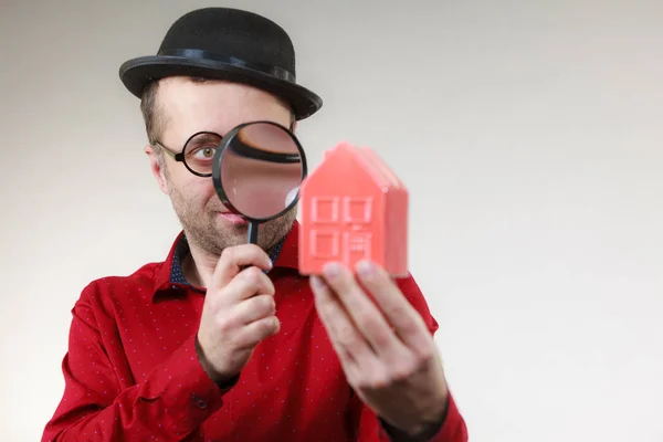 Man magnifying red house — Stock Photo, Image
