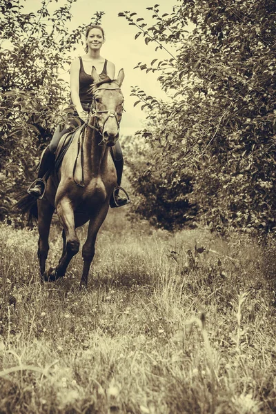 Mladá žena zbavit na koni — Stock fotografie