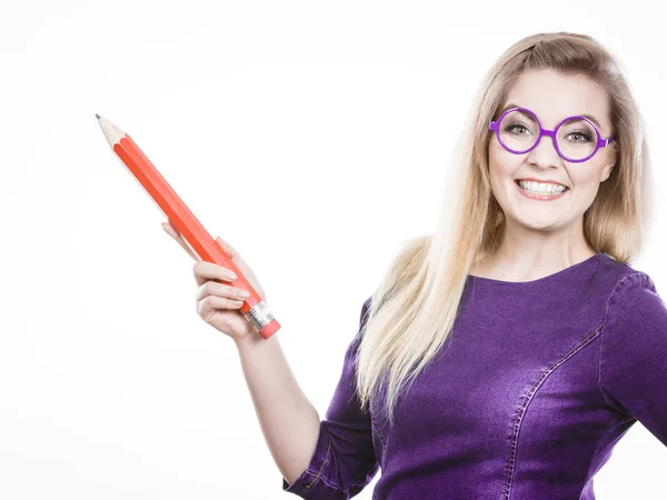 Hymyilevä nainen pitää iso kynä kädessä — kuvapankkivalokuva