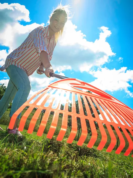 Unusual angle of woman raking leaves