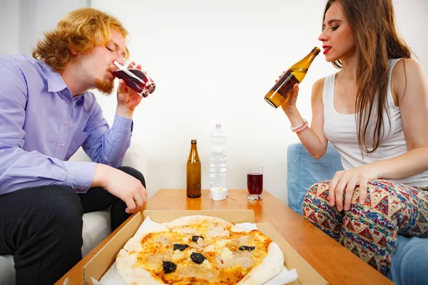 Koppel pizza eten en bier drinken — Stockfoto