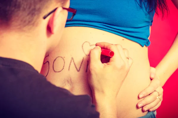 Barriga de mulher grávida, pai desenhando nele — Fotografia de Stock