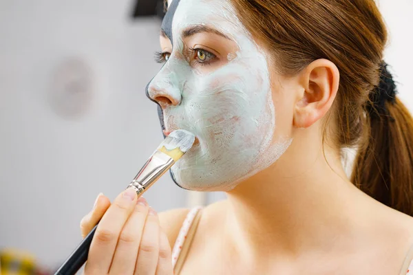 Meisje zwart masker op halve gezicht apply witte modder — Stockfoto