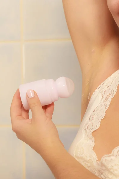 Женщина наносит дезодорант в подмышку — стоковое фото