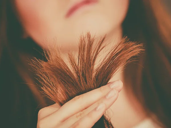 彼女の乾燥した髪の両端を見て心配する女性 — ストック写真