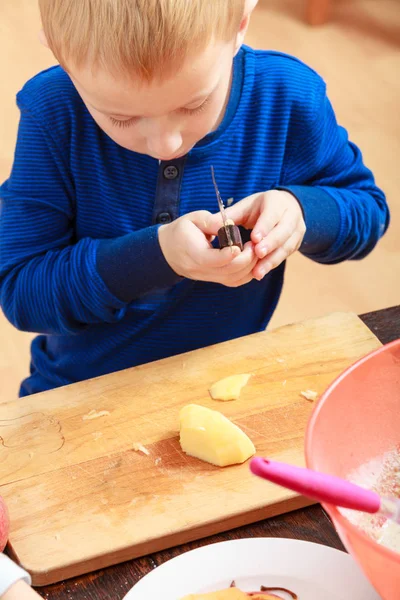 Niño pelando manzanas con cuchillo y comiendo — Foto de Stock