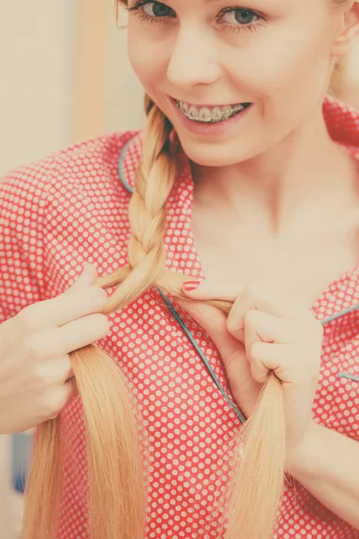 Frau macht Zopf auf blonden Haaren — Stockfoto