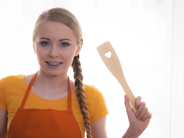 Woman holding wooden spatula with heart — Stock Photo, Image