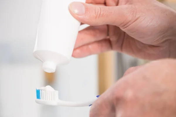 歯ブラシに歯磨き粉を置く人 — ストック写真