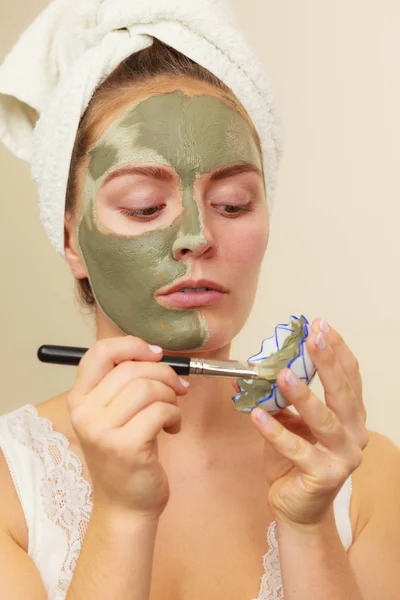 Femme appliquant avec un masque de boue d'argile brosse sur son visage — Photo