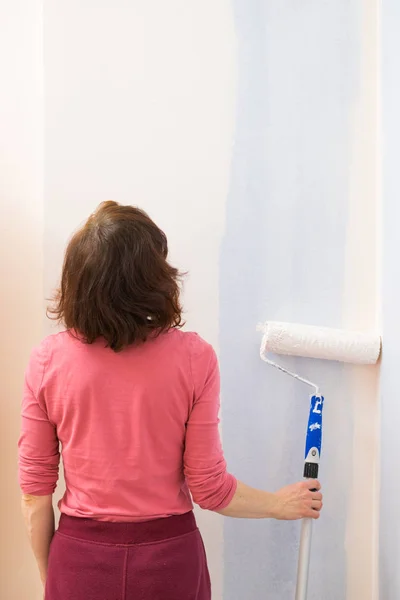 Kvinna som ansöker måla på väggen — Stockfoto