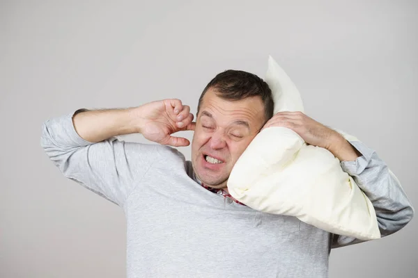 Hombre somnoliento con almohada cerrando su oreja —  Fotos de Stock