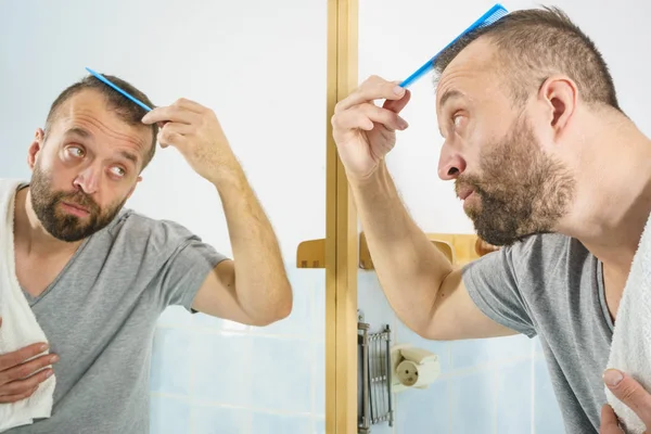 Homem usando pente no banheiro — Fotografia de Stock