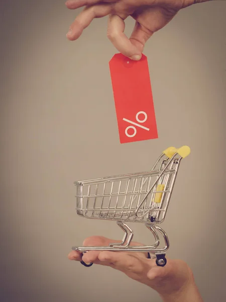 Mão com carrinho de compras e etiqueta de venda . — Fotografia de Stock