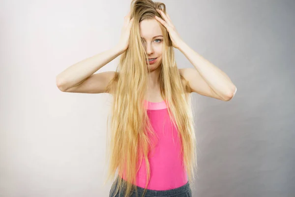 Jonge vrouw aan haar lange haar te raken — Stockfoto