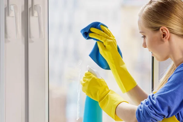 Mujer ventana de limpieza en casa — Foto de Stock