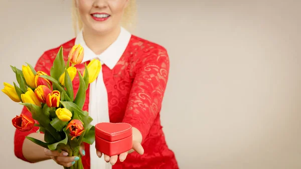 Kvinna anläggning tulpaner och gåva — Stockfoto