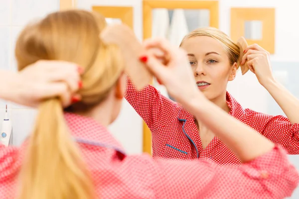 Mulher penteando seu cabelo comprido no banheiro — Fotografia de Stock