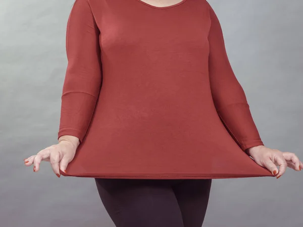 Mujer mostrando el tamaño de la túnica superior roja —  Fotos de Stock